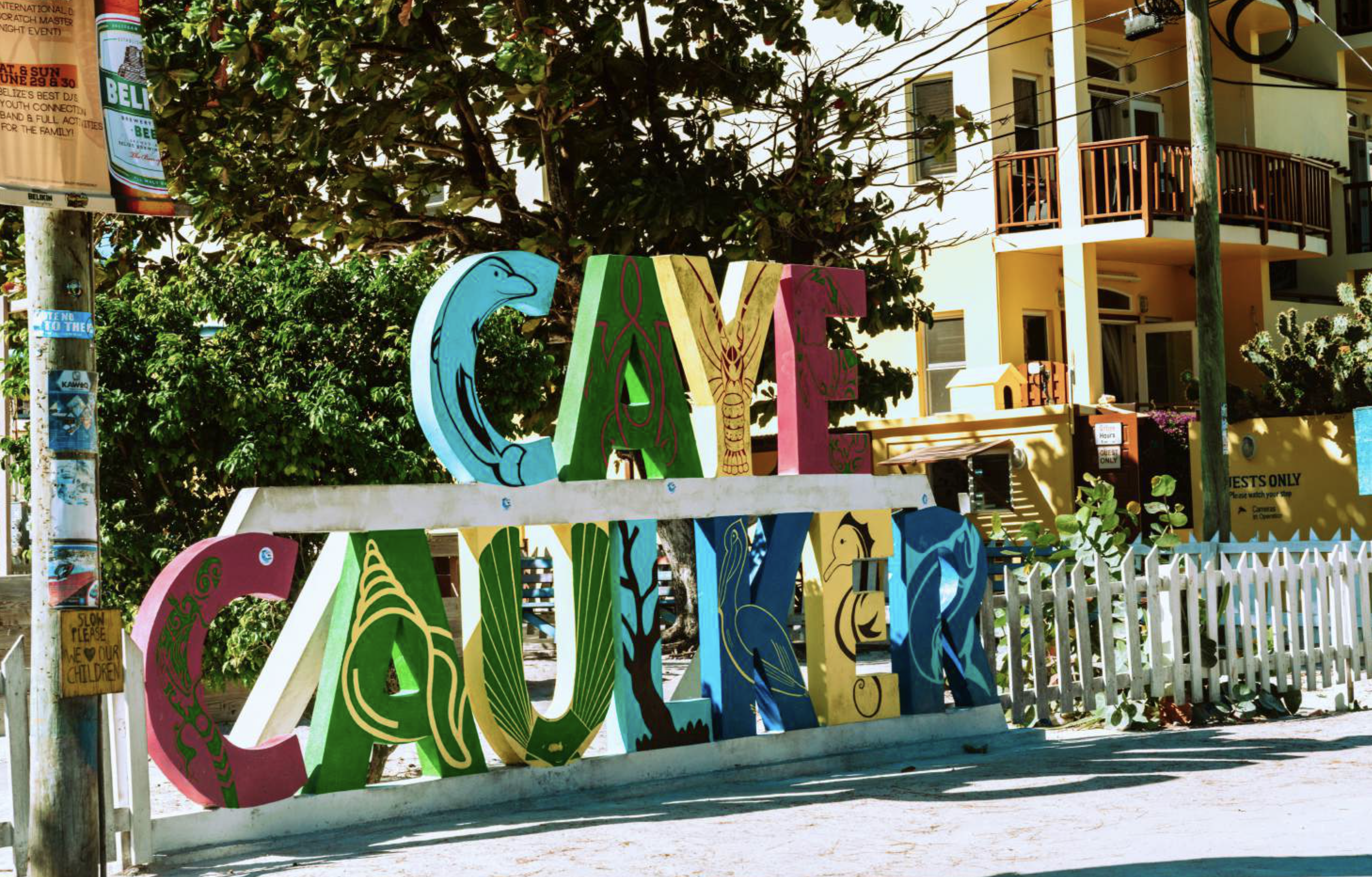 A wooden colorfully painted sign that says Caye Caulker